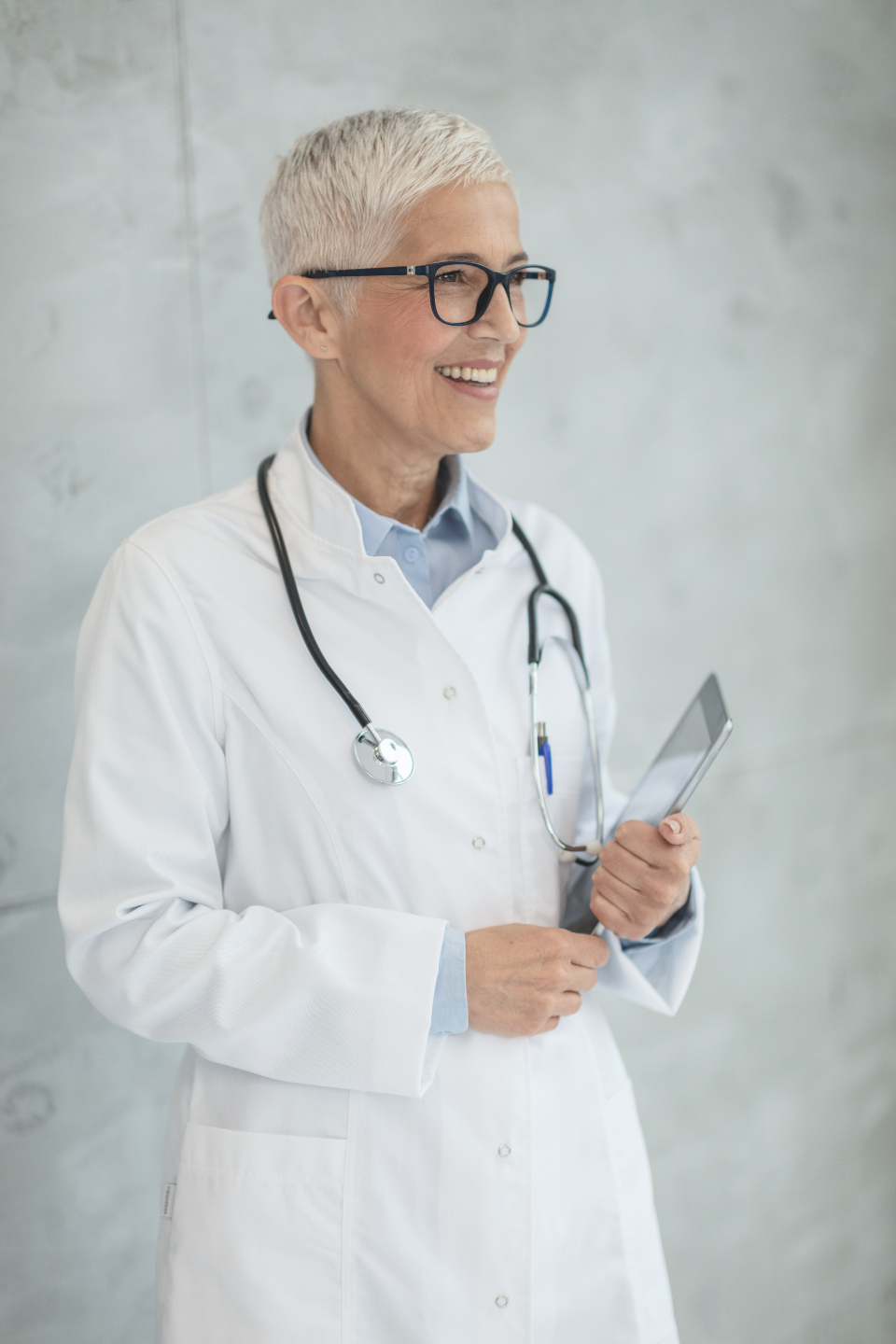 A smiling doctor holding a tablet